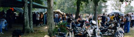 Motorcycles and attendees gathered outdoors at the Pair-A-Dice Swap Meet